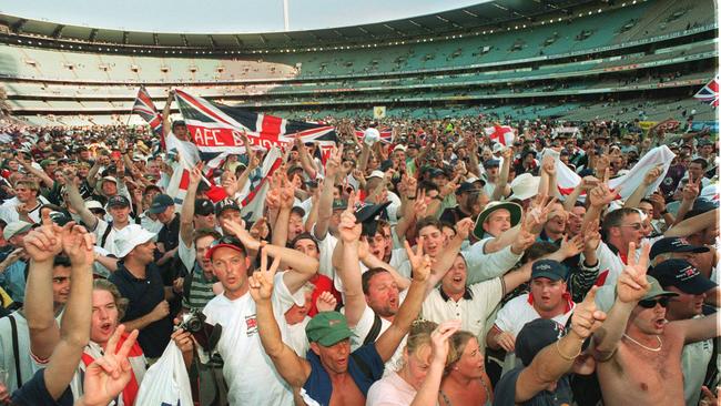 The Balmy army celebrate England's win by crowding on to the MCG field.