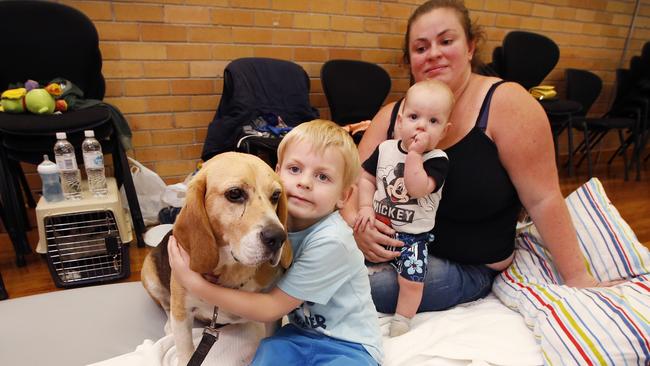 Mum Sally Rowe with Koby, 5, Samuel, 8 months, and Bowser the beagle wait it out at the Cobden relief centre. Picture: David Caird