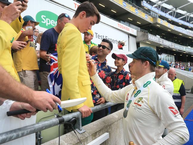 Steve Smith signs an autograph for a fan in the crowd after Australia bowl England out on the fifth day of the first Ashes cricket Test. Picture: Lindsey Parnaby/AFP