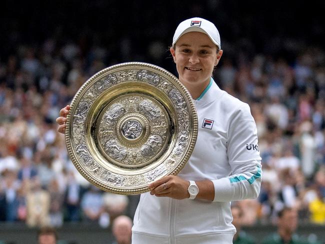 (FILES) This file photo taken on July 10, 2021 shows Australia's Ashleigh Barty holding the trophy after winning her women's singles match against the Czech Republic's Karolina Pliskova on the 12th day of the 2021 Wimbledon Championships at the All England Tennis Club in Wimbledon, southwest London. - Three-time Grand Slam winner and world number one Ashleigh Barty stunned the tennis world on March 23, 2022 by announcing her early retirement from the sport at the age of just 25. (Photo by AELTC/Jed Leicester / AFP) / RESTRICTED TO EDITORIAL USE