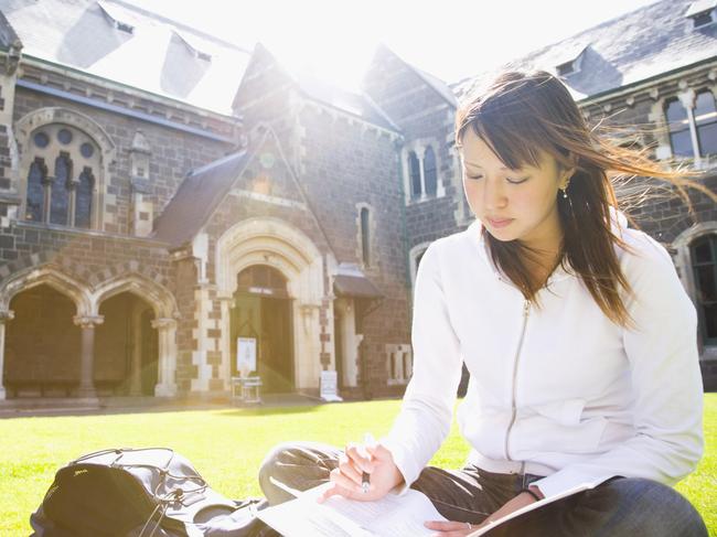 Young woman studying on lawn.Getty