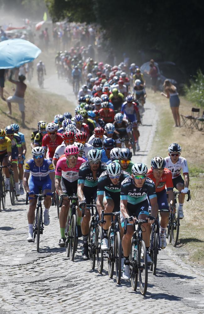 The peloton snakes its way over the first cobblestone sector. Picture: AP