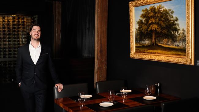 Landscape restaurant manager David Newman next to one of celebrated Colonial artist John Glover’s classic Tasmanian landscape paintings. Picture: Mireille Merlet