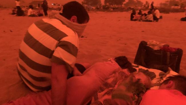 Baxter's brother in law, Angus McFarlane, his two young girls and Henry Baxter, 10, shelter on the sand.