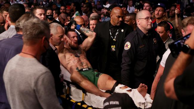 Conor McGregor of Ireland is carried out of the arena on a stretcher after injuring his ankle in the first round of his lightweight bout against Dustin Poirier during UFC 264 in 2021. (Photo by Stacy Revere/Getty Images)