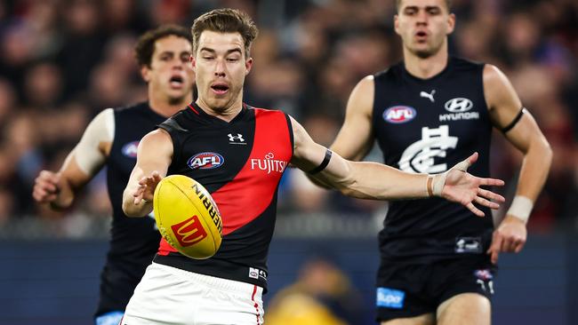 MELBOURNE, AUSTRALIA - JUNE 11: Zach Merrett of the Bombers kicks the ball during the 2023 AFL Round 13 match between the Carlton Blues and the Essendon Bombers at the Melbourne Cricket Ground on June 11, 2023 in Melbourne, Australia. (Photo by Dylan Burns/AFL Photos via Getty Images)