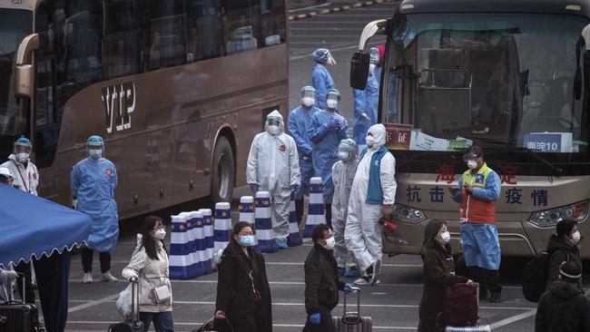 Travellers from Hubei province gather to take buses while being processed and taken to do 14 days of quarantine, after arriving by train in Beijing on April 10. China lifted its lockdown on Wuhan, the first epicentre of COVID-19 after 76 days this week, allowing healthy people to leave.