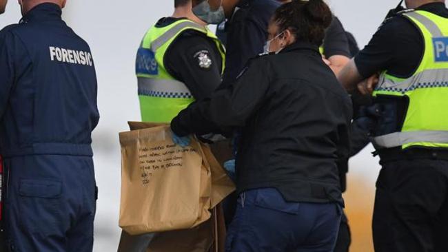 Police collecting evidence on Tuesday, which included a brown paper bag marked as containing a hardcover book in Arabic.