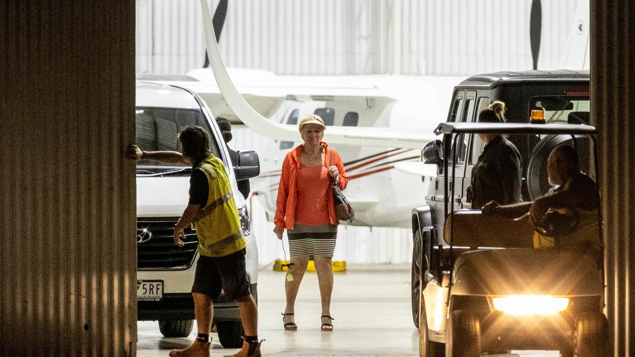 A woman believed to be Shane Warne’s mother holds a white rose inside the hangar after his body returned to Australia. Picture: Jake Nowakowski