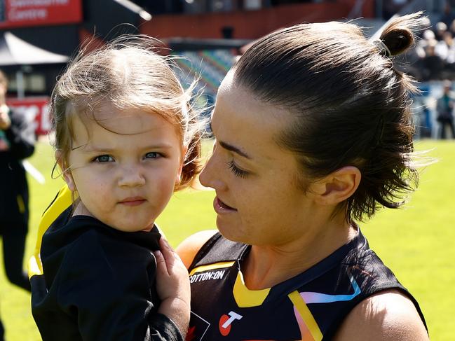 MELBOURNE, AUSTRALIA - OCTOBER 12: Kate Dempsey of the Tigers and daughter Pippa are seen during the 2024 AFLW Round 07 match between the Richmond Tigers and the Geelong Cats at Swinburne Centre on October 12, 2024 in Melbourne, Australia. (Photo by Michael Willson/AFL Photos via Getty Images)