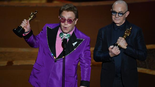 Elton John and Bernie Taupin accepting an award at the 92nd Oscars at the Dolby Theatre in Hollywood, California on February 9, 2020. (Photo by Mark RALSTON / AFP)