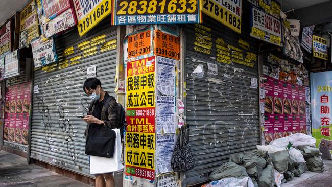 A man stands in front of a vacant shop in Hong Kong. Picture: AFP