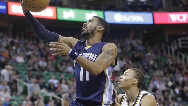 Memphis Grizzlies guard Mike Conley lays the ball up against Utah Jazz guard Dante Exum.