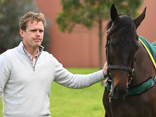 MELBOURNE, AUSTRALIA - SEPTEMBER 30: Trainer Edward Cummings poses with Duais and handler Alex Lemarie during a media opportunity at Flemington Racecourse on September 30, 2022 in Melbourne, Australia. Duais is one of the favourites in The Group One Turnbull Stakes tomorrow. (Photo by Vince Caligiuri/Getty Images)