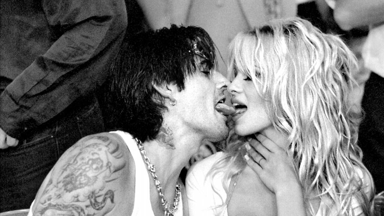 Actor Pamela Anderson and rock star husband Tommy Lee kiss at a Mike Tyson fight in 1995.