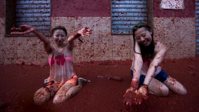 Revellers take part in the annual "tomatina" festivities in the village of Bunol, near Valencia on August 28, 2013. Some 22,000 revellers hurled 130 tonnes of squashed tomatoes at each other drenching the streets in red in a gigantic Spanish food fight known as the Tomatina. AFP PHOTO / GABRIEL GALLO