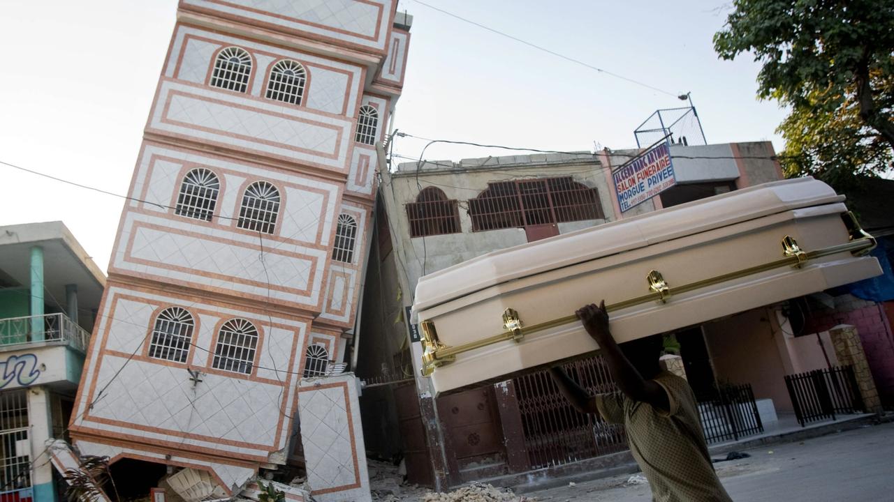 A man carries a coffin in Port-au-Prince after the 2010 quake.