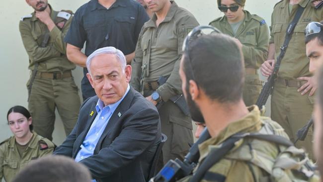 Prime Minister Benjamin Netanyahu, centre, visits a training base targeted by a deadly Hezbollah drone strike a day earlier, October 14, 2024. (Kobi Gideon/GPO)