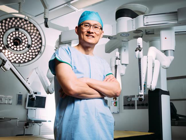 Robotic surgeon Felix Chan pictured in the operating theater at Liverpool Hospital with a robotic surgical system he uses to perform surgery. Picture: Jonathan Ng