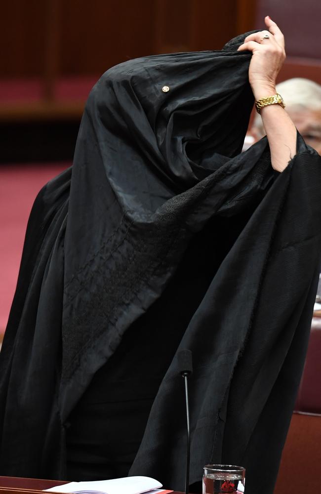 Hanson begins to take off the burqa. Picture: AAP