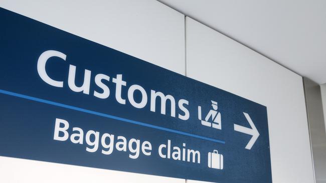 "Customs" and "Baggage Claim" direction sign at Sydney International Airport.