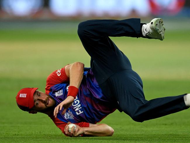 TOPSHOT - England's Chris Woakes takes the catch to dismiss Australia's Steven Smith (not pictured) during the ICC menâs Twenty20 World Cup cricket match between Australia and England at the Dubai International Cricket Stadium in Dubai on October 30, 2021. (Photo by Aamir QURESHI / AFP)