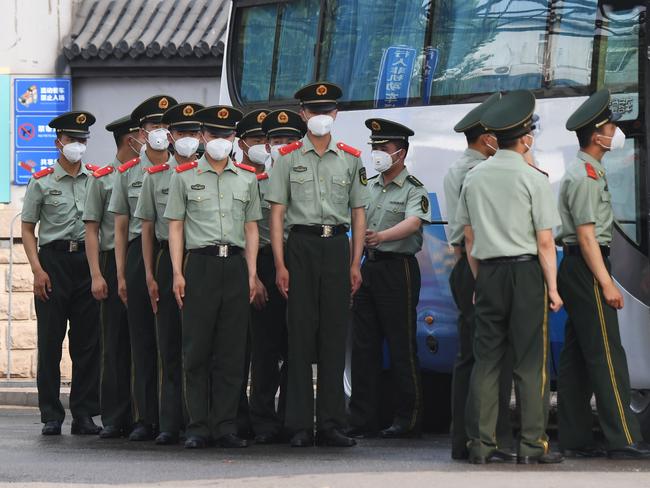 TOPSHOT - Chinese paramilitary police prepare to guard entrances to the closed Xinfadi market in Beijing on June 13, 2020. - The huge wholesale market has become the centre of focus for a new cluster of coronavirus cases in Beijing, where nervous local officials have begun mass testing, closing schools and neighbourhoods, and turned sharp scrutiny towards the food supply chain. (Photo by GREG BAKER / AFP)