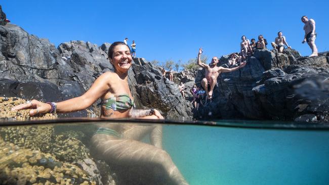 27 year old Lauren Nardone from New York cools off in rock pools at Granite Bay as Will Peregrine 23, from Brussels makes a splash as summer conditions hit the Queensland Coast. Picture: Lachie Millard