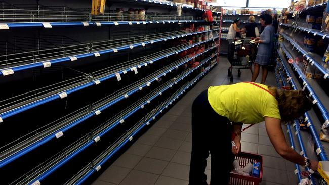 Situation worsening ... Shoppers stand in an aisle with empty shelves in a supermarket in Athens. Picture: AFP/ARIS MESSINIS