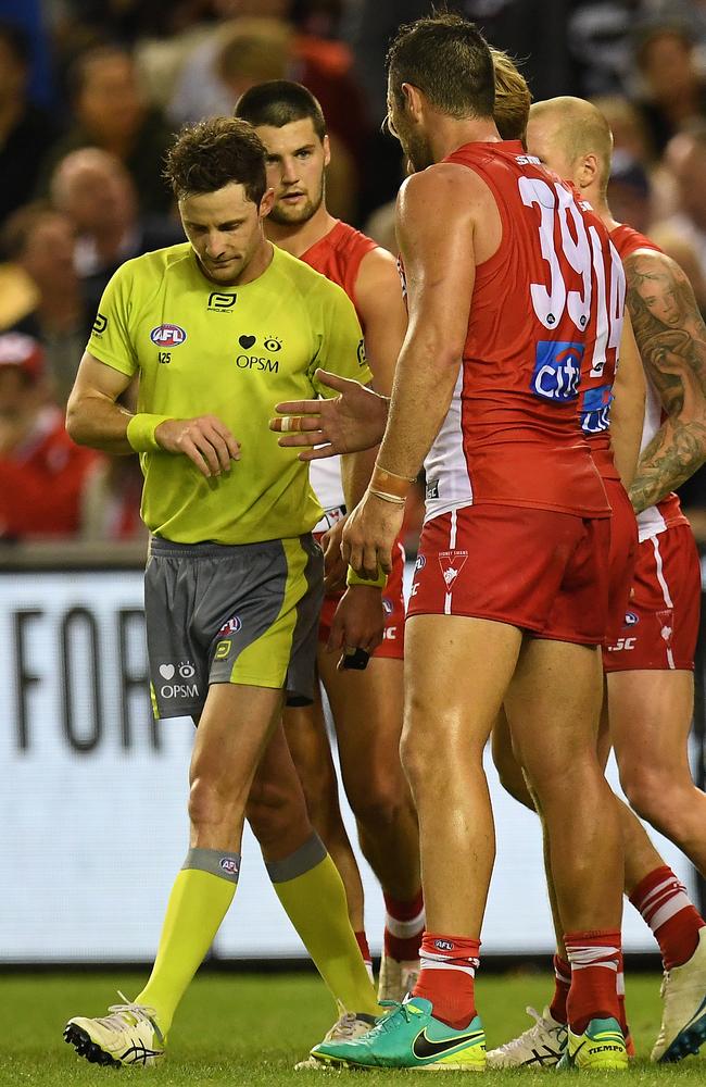 Swans players seek some clarity from ump Brendan Hosking after he awarded a free kick against Callum Mills for a rushed. Picture: AAP