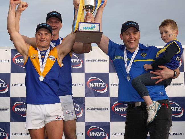 Jake McKenzie, captain Jack Purton-Smith and coach Marc Bullen hoist the silverware after Deer Park defeated Altona in the WRFL Division 1 grand final. Picture: Local Legends Photography