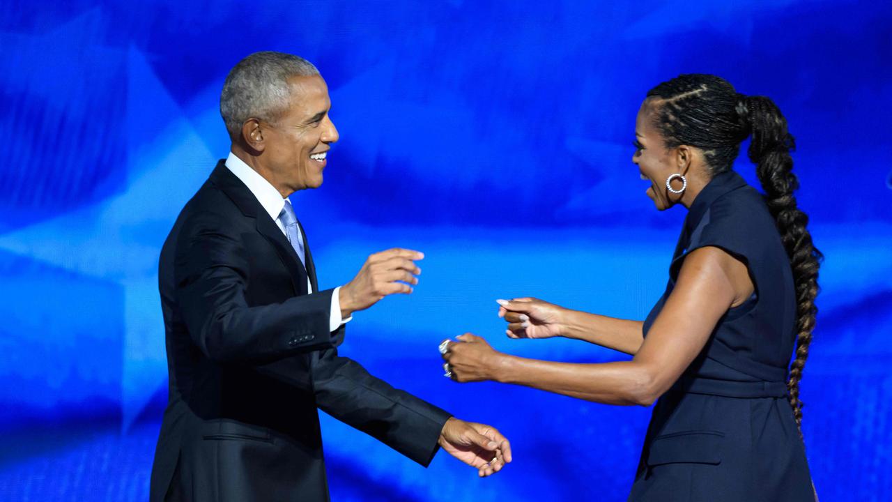 Former US President Barack Obama reaches out to embrace his wife and former First Lady, Michelle Obama, after she introduced him to the stage on the second day of the Democratic National Convention. Picture: AFP