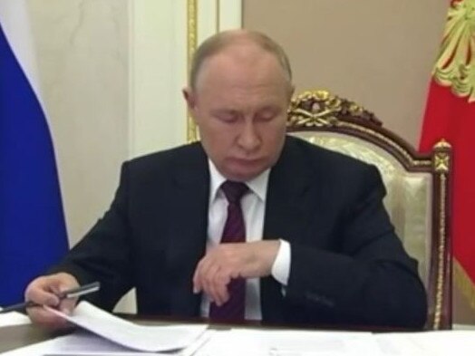 Vladimir Putin appears confused as he looks for his watch on the wrong wrist. Picture: Supplied