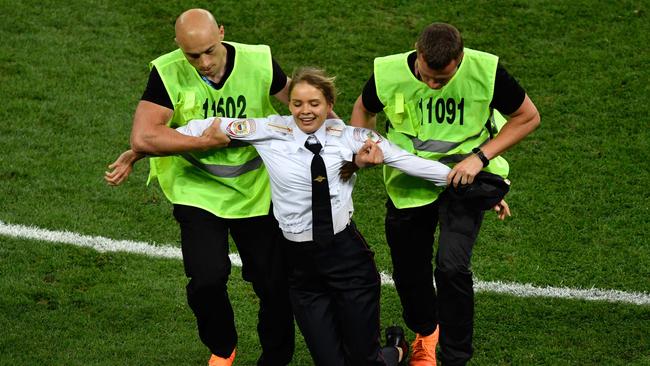 A protester is evacuated from the football pitch during the Russia 2018 World Cup final. Picture: AFP