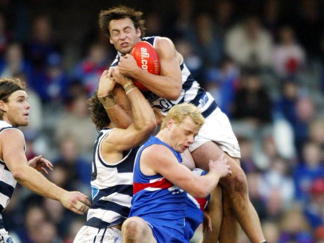 Jimmy Bartel crashes over the top of Geelong teammate Matthew Scarlett and Adam Cooney to take a spectacular grab against the Western Bulldogs in 2004.