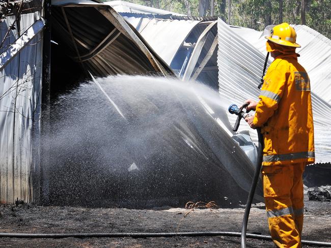 A rural fire fighter extinguishes the remains of a vicious blaze in Glenwood this afternoon.