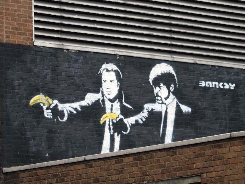 A Banksy mural of John Travolta and Samuel L Jackson holding bananas instead of guns in a parody of the film Pulp Fiction. The mural in London was painted over by a graffiti removal team. Picture: Supplied