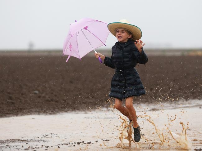 Grace Groves, 7, rejoices in the rain on her family farm near Gunnedah. Picture: Peter Lorimer.