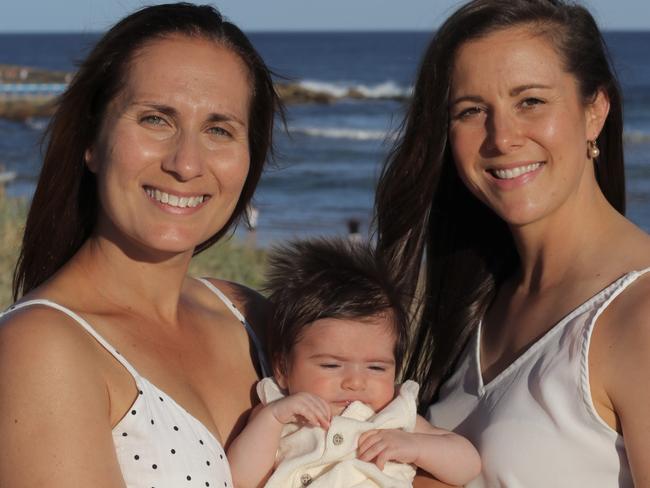 Jo Greco, left, holding baby Morgan, used a sperm donor to start a family. Pictured with her wife Ceri, at Freshwater Beach. Picture: Supplied.