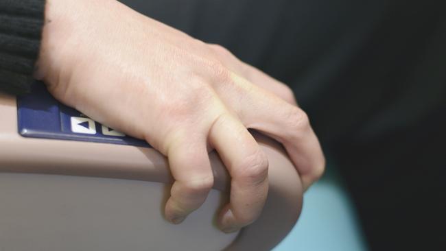 A female passenger on a jet aircraft grips the seat armrest from fear of flying.