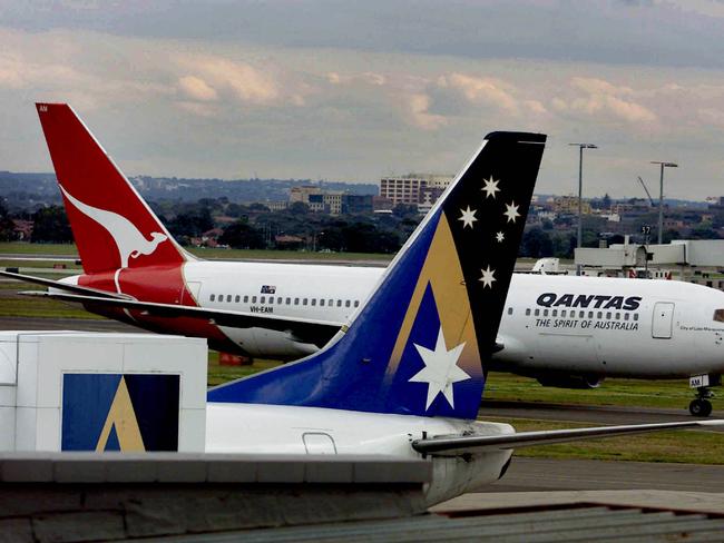 Qantas aeroplane plane moving past Ansett Airlines aeroplane, which lays idle in 2001.