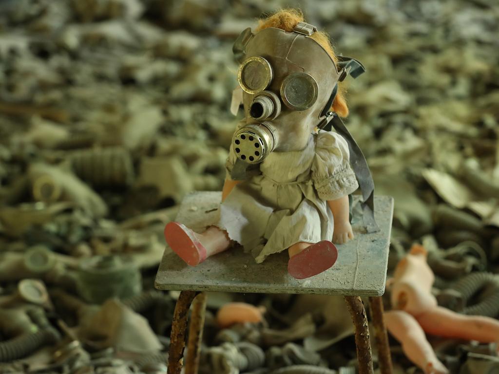 A doll, likely arranged by a tourist, dressed with a gas mask sits on a chair among hundreds of gas masks lying on the floor of abandoned School Number 3 in the ghost town of Pripyat. Picture: Sean Gallup/Getty Images