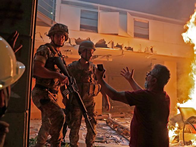 A Lebanese protester speaks to soldiers at the headquarters of the Lebanese association of banks in downtown Beirut. Picture: AFP