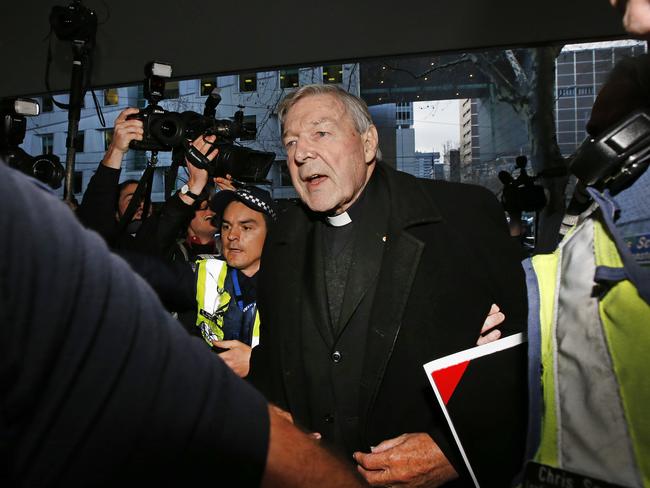 Media crews surround George Pell as he arrives at the Melbourne Magistrates’ Court. Picture: David Caird