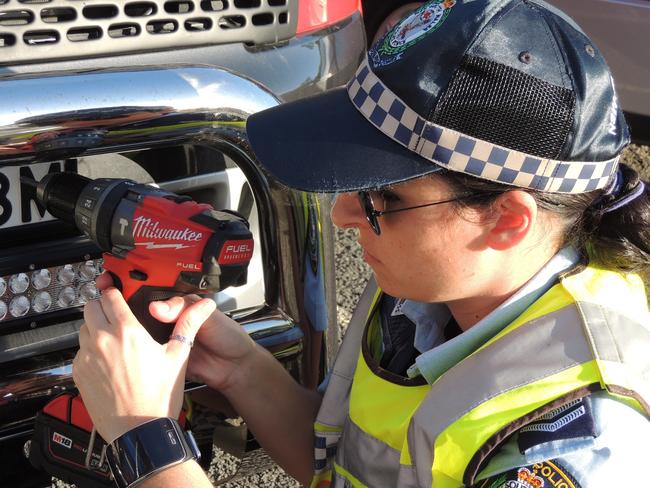 Police from The Hills fixing tamper-free antitheft screws to numberplates last year.