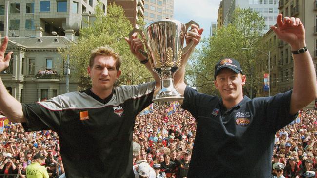 James Hird and Michael Voss holding up the 2001 AFL premiership trophy during the Grand Final parade.