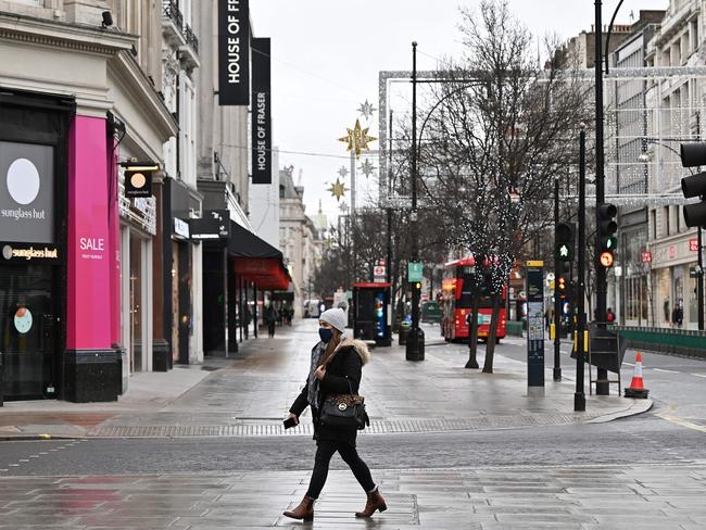 A pedestrian wearing a mask walk past shops closed down due to lockdown restrictions, on an empty Oxford Street in London. Picture: AFP