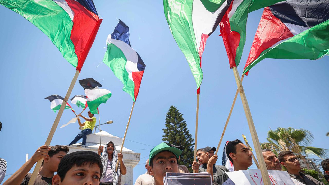 Palestinians lift national flags and placards during a demonstration in Gaza City on July 3, 2023, protesting an Israeli military operation in the occupied West Bank. (Photo by MAHMUD HAMS / AFP)