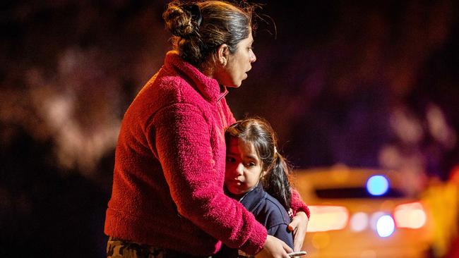 A young Exford Primary School student involved in the collision is comforted by a loved one. Picture: Jake Nowakowski