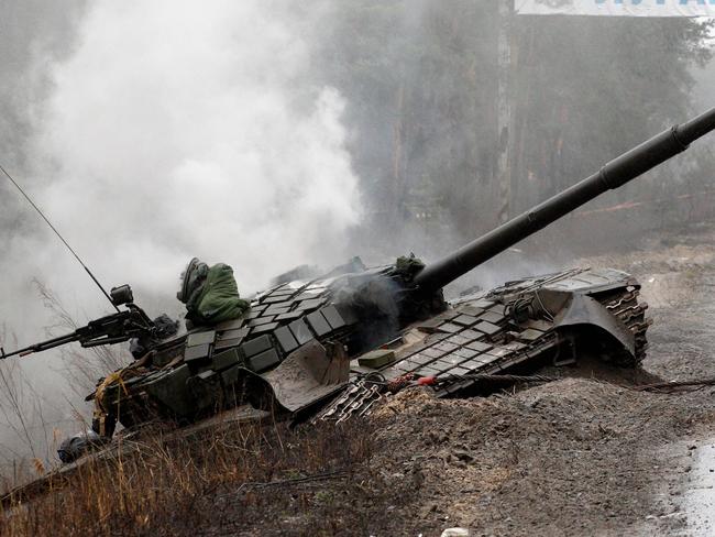 Smoke rises from a Russian tank destroyed by the Ukrainian forces on the side of a road in Lugansk region on February 26, 2022. - Russia on February 26 ordered its troops to advance in Ukraine "from all directions" as the Ukrainian capital Kyiv imposed a blanket curfew and officials reported 198 civilian deaths. (Photo by Anatolii Stepanov / AFP)